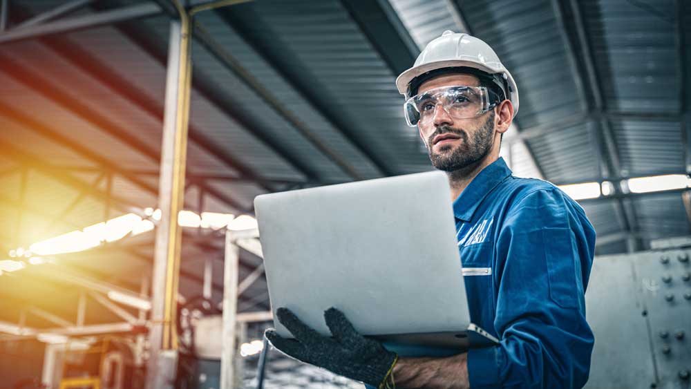 Man looking at laptop in Industrial Environment