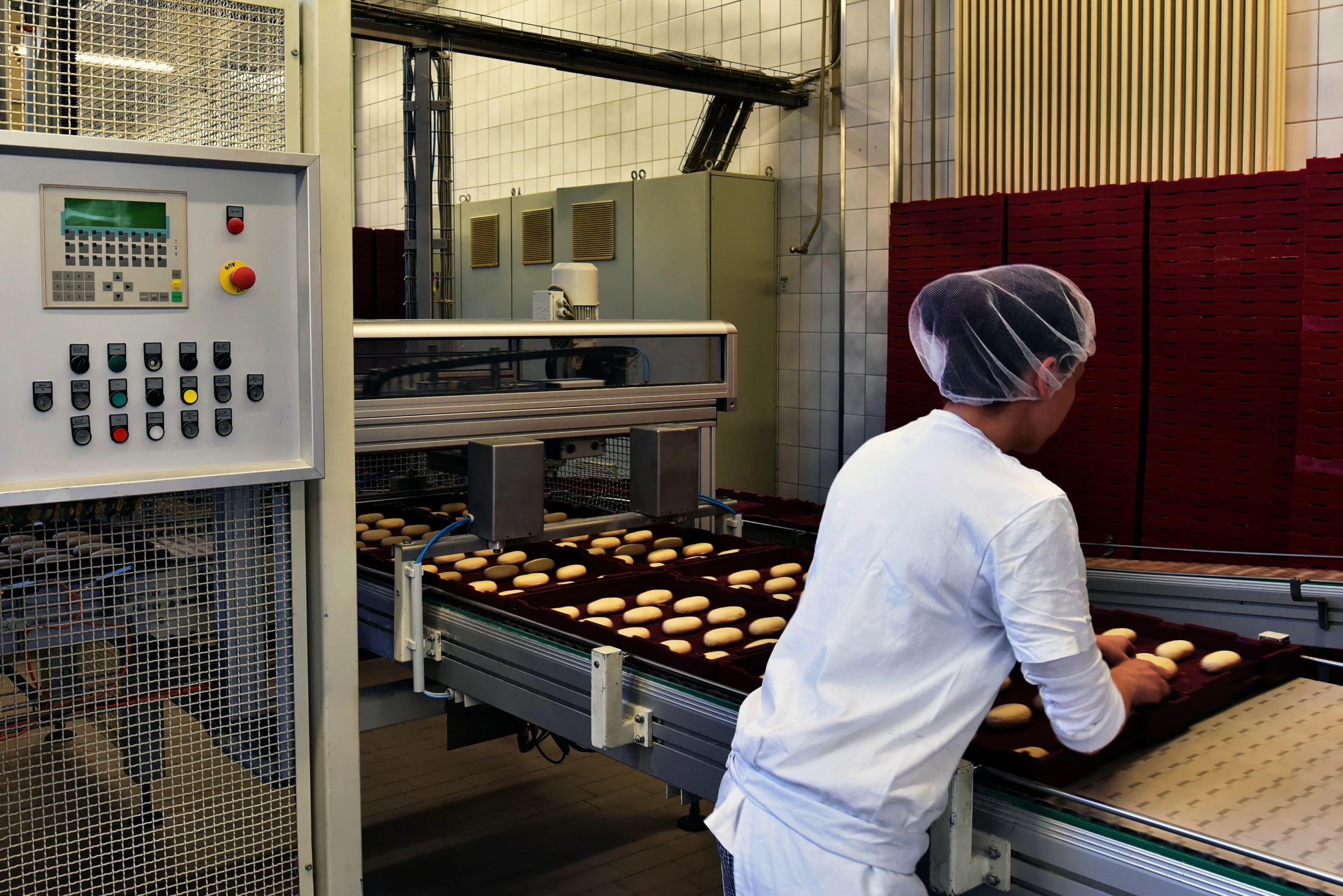 Bakery worker next to a conveyor belt