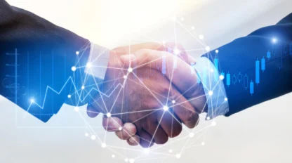Two people in business suits shaking hands, with digital network and financial graph overlays representing a business agreement or partnership.